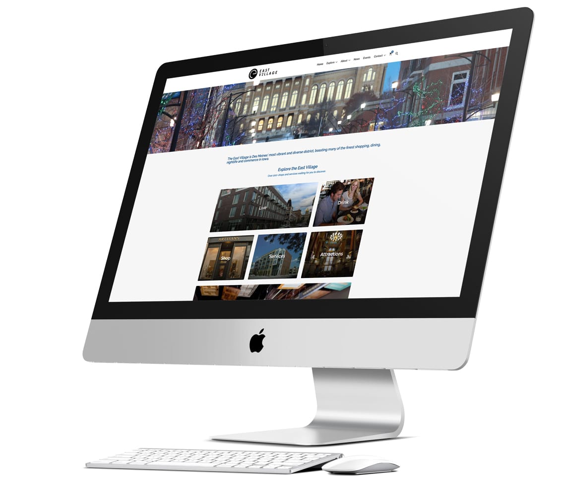 iMac computer, with keyboard and mouse displaying home page of client's website.