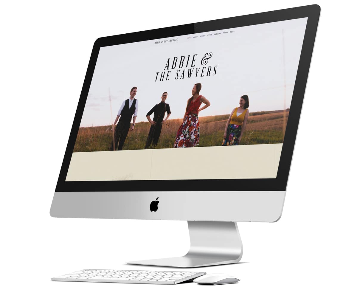 iMac computer, with keyboard and mouse displaying home page of client's website.